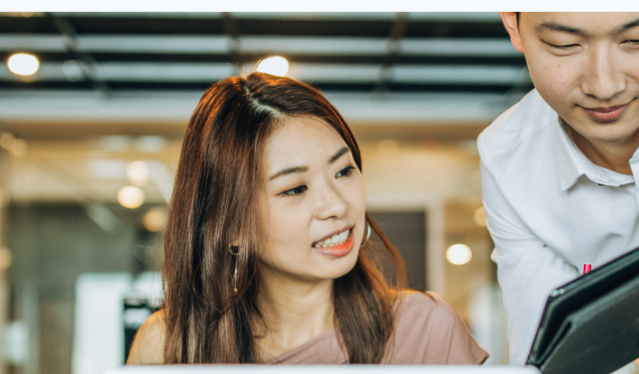 Asian man and woman looking at a tablet